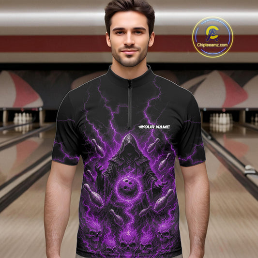 A man wearing a black short-sleeve quarter-zip bowling shirt with a purple lightning and skull graphic, standing in a bowling alley.