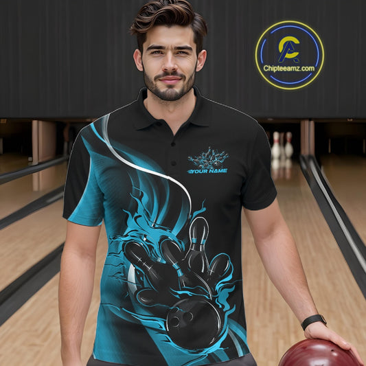 Male model seen from the front in a bowling lane wearing a black and blue polo shirt featuring a flame bowling ball striking pins in a dynamic sports action scene.