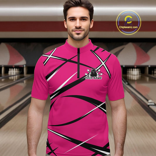 Front view of a male bowler wearing a pink, black, and white bowling quarter zip shirt in a bowling lane