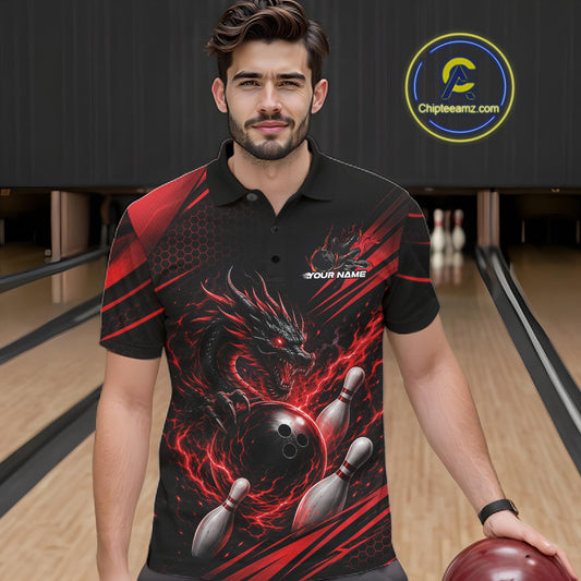 A man wearing a black short-sleeve polo shirt with a red and black dragon graphic over bowling pins and a bowling ball, standing in a bowling alley holding a bowling ball.