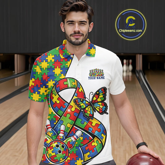 Male model in a bowling lane wearing a white polo shirt, front view featuring autism puzzle ribbon, butterfly, and bowling ball striking pins design