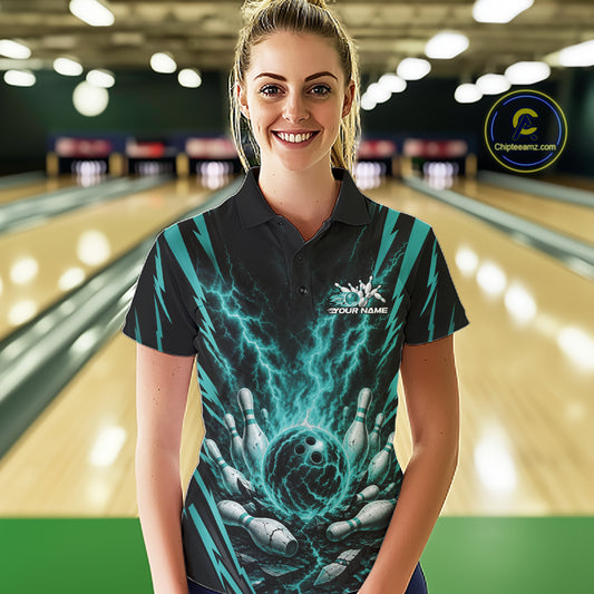 A woman stands in a bowling alley wearing a black short-sleeve polo shirt with a vibrant teal and black lightning-bolt graphic on the front, featuring a white 'YOUR NAME' placeholder logo on the chest.