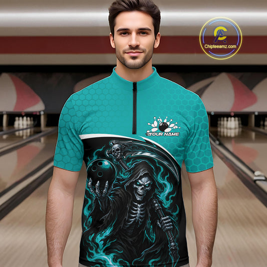 A man wearing a teal short-sleeve bowling jersey with a black front graphic of a grim reaper and bowling theme, standing in a bowling alley. The jersey has a black zipper at the neck