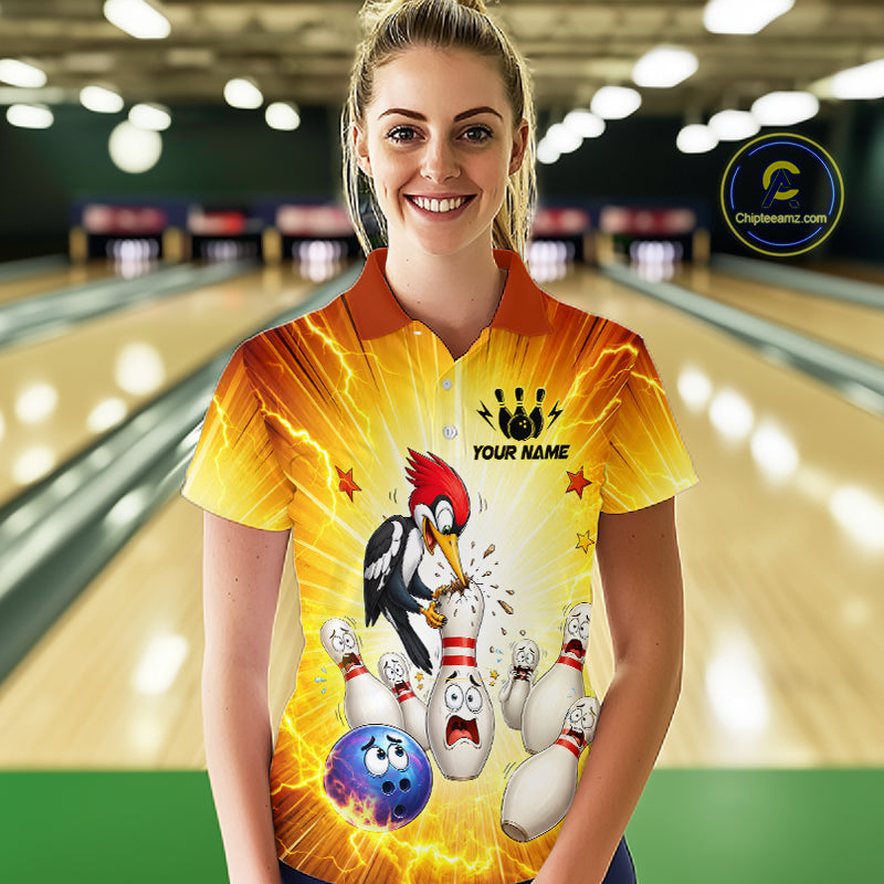 Woman wearing a bowling-themed shirt with a woodpecker design in a bowling alley.