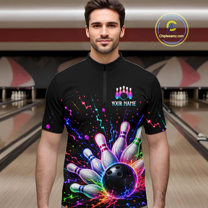 Man wearing a black bowling shirt with colorful design in a bowling alley.