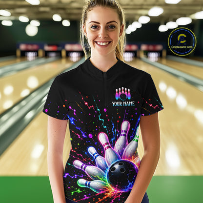 Person wearing a black bowling-themed shirt with colorful design in a bowling alley.