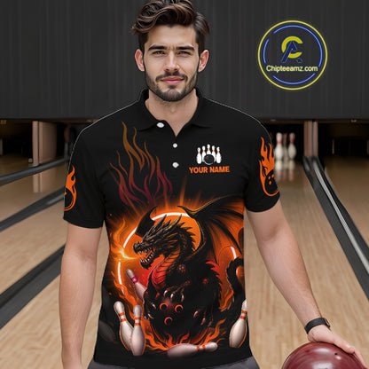 A man wearing a black short-sleeve polo shirt with a fiery dragon graphic and bowling pins, standing in a bowling alley. The shirt features orange flames, a black dragon, and bowling pins, with 'YOUR NAME' printed on the chest.