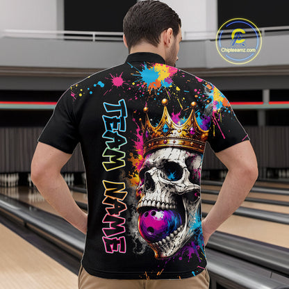 Person wearing a colorful bowling shirt with a skull and crown design in a bowling alley.