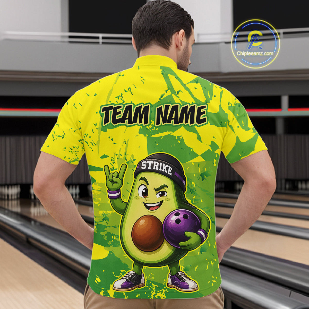 Person wearing a bright yellow and green bowling shirt with an avocado character design in a bowling alley.