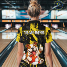 Load image into Gallery viewer, Female model wearing a custom black yellow bulldog bowling polo shirt back view displaying the personalized team name above a playful cartoon bulldog graphic at the bowling alley