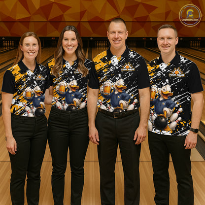 Four people standing together in a bowling alley wearing matching black short-sleeve bowling shirts with a colorful cartoon duck graphic and black pants. 