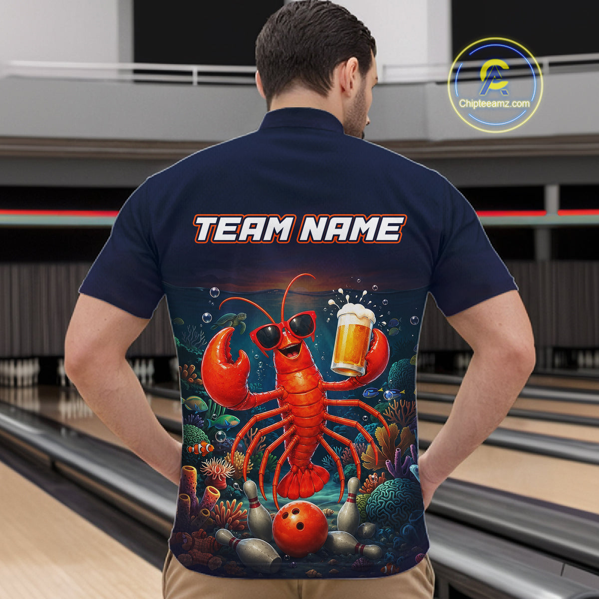 Man wearing a navy blue shirt with a colorful lobster design and 'TEAM NAME' text, standing in a bowling alley.