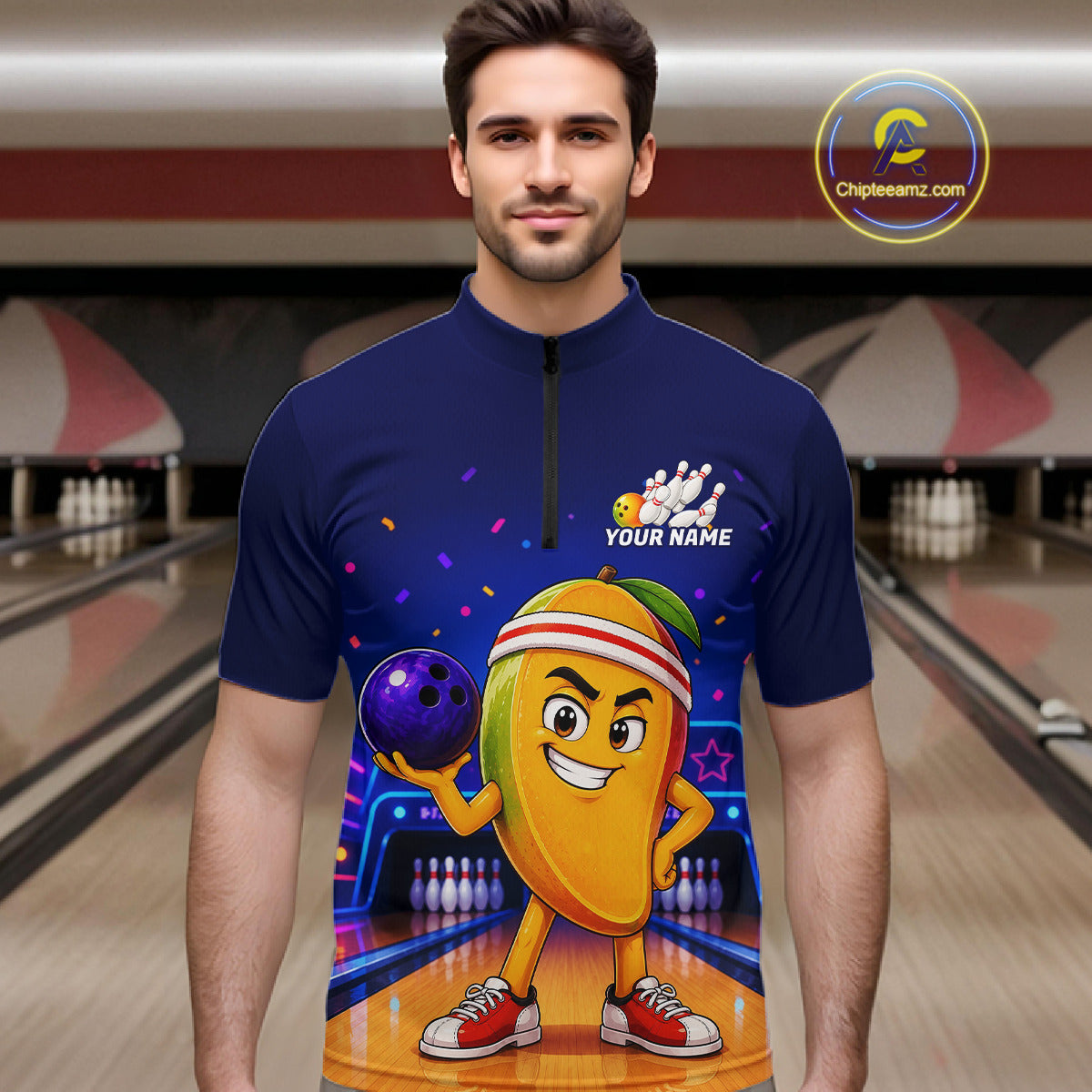 Man wearing a blue shirt with a cartoon character holding a bowling ball in a bowling alley.