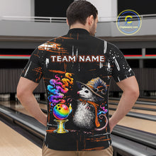 Load image into Gallery viewer, A man viewed from behind wearing a black bowling-themed short-sleeve shirt with a colorful graphic of a possum in a witch hat next to a rainbow bowling ball, with 'TEAM NAME' printed across the upper back. The background shows bowling lanes.