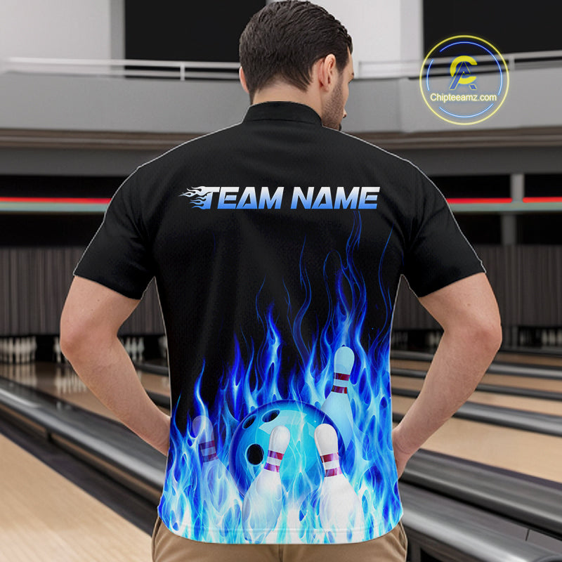 Man wearing a black bowling shirt with blue flames and a bowling ball design, standing on a bowling lane.