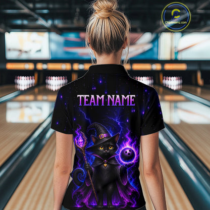 A woman viewed from behind wearing a black short-sleeve polo shirt with a colorful graphic of a witch cat and purple lightning, standing in a bowling alley. The shirt has 'TEAM NAME' printed on the back.