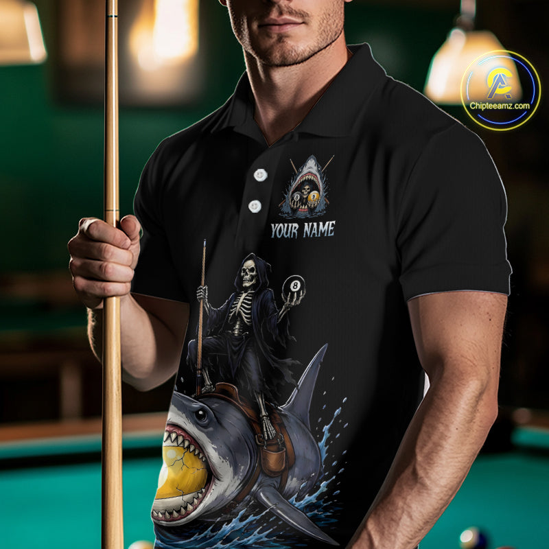 Man wearing a black polo shirt with a shark and skeleton design, holding a pool cue in a billiards setting.