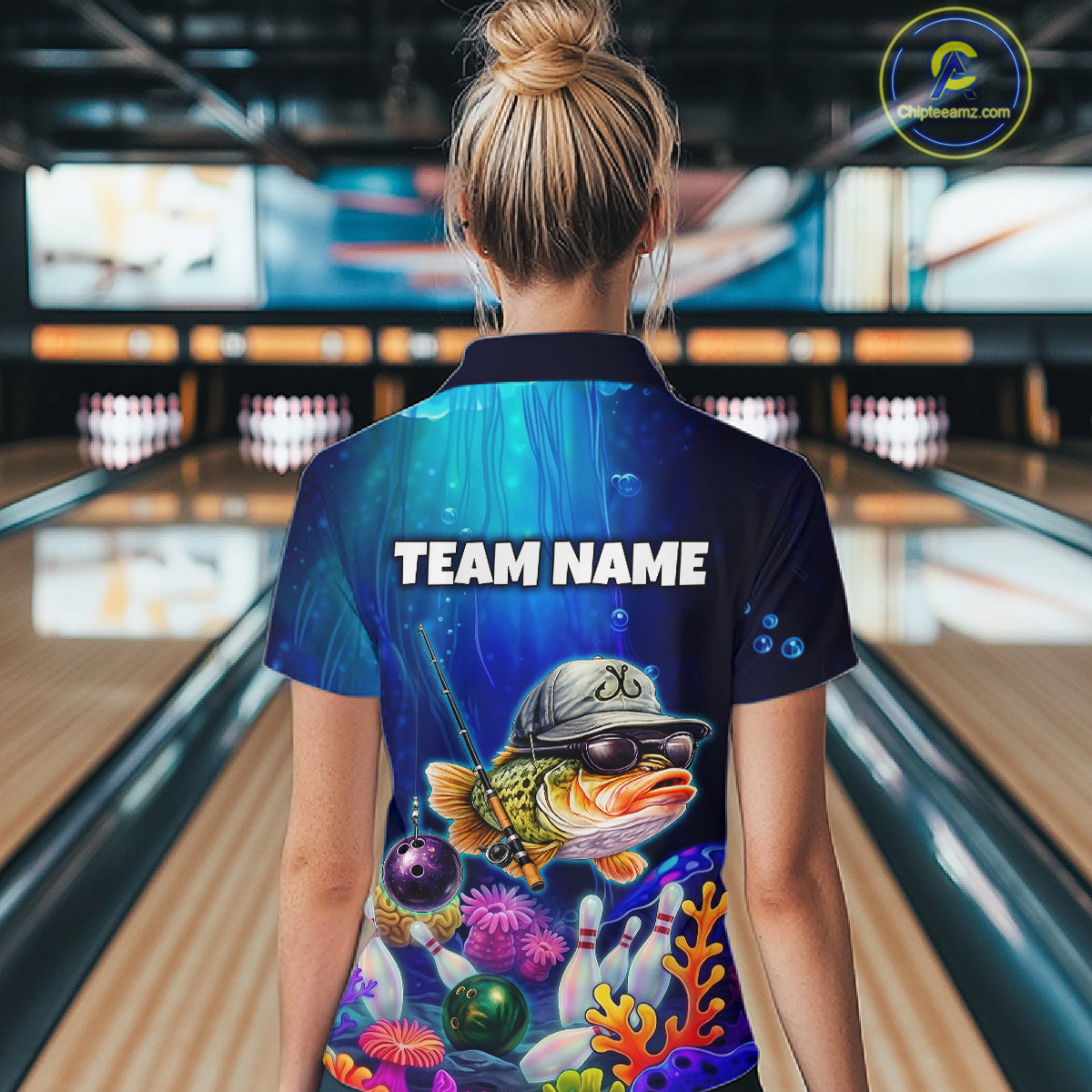 Woman wearing an underwater-themed bowling quarter zip featuring a fish mascot wearing sunglasses and a cap, colorful coral reefs, bowling pins, bowling balls, and custom team text.