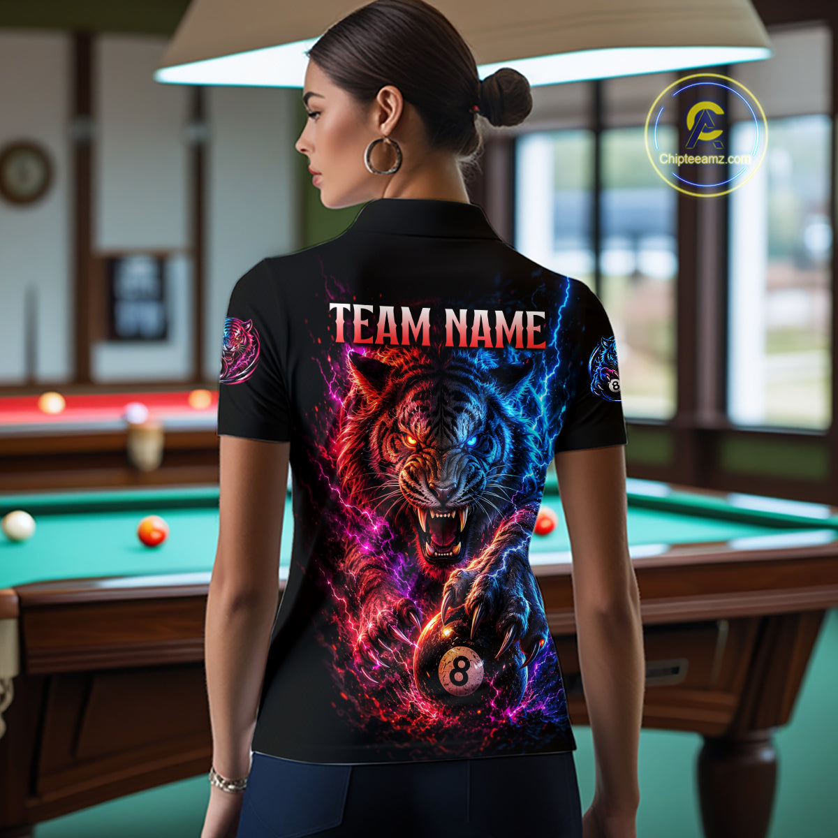 Person wearing a black t-shirt with a colorful tiger design and 'Team Name' text in a pool hall.