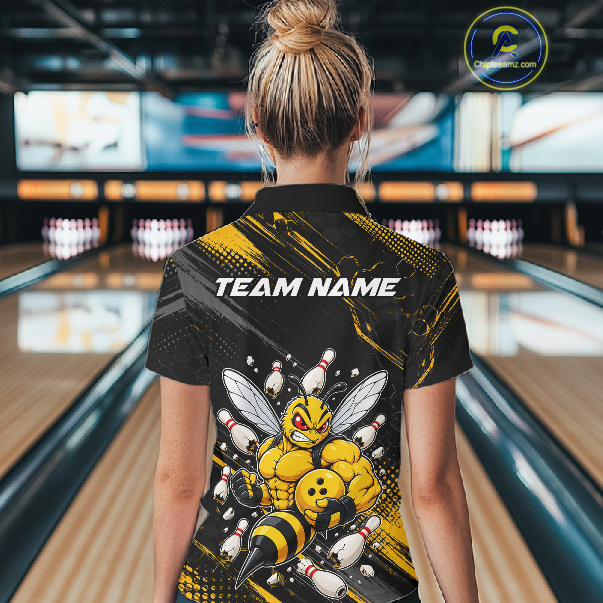 Women wearing bowling quarter zip shirt featuring a muscular bee holding a bowling ball surrounded by pins on black yellow background.