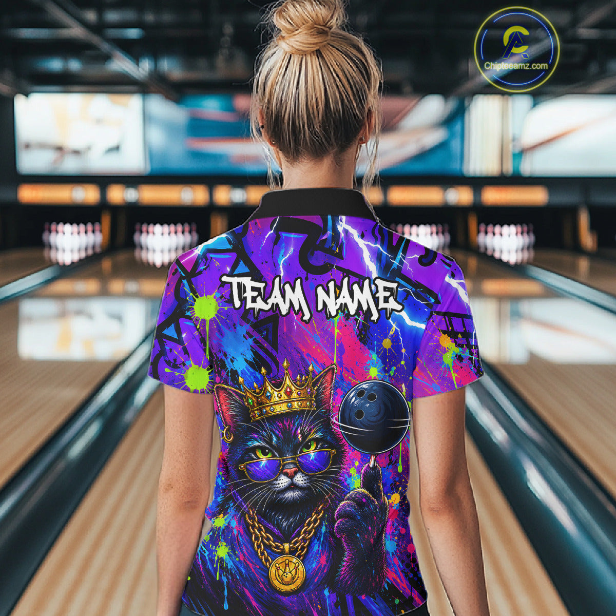 Women wearing personalized bowling polo shirt with a crowned cat holding a bowling ball, blended with colorful paint strokes and graphic patterns.