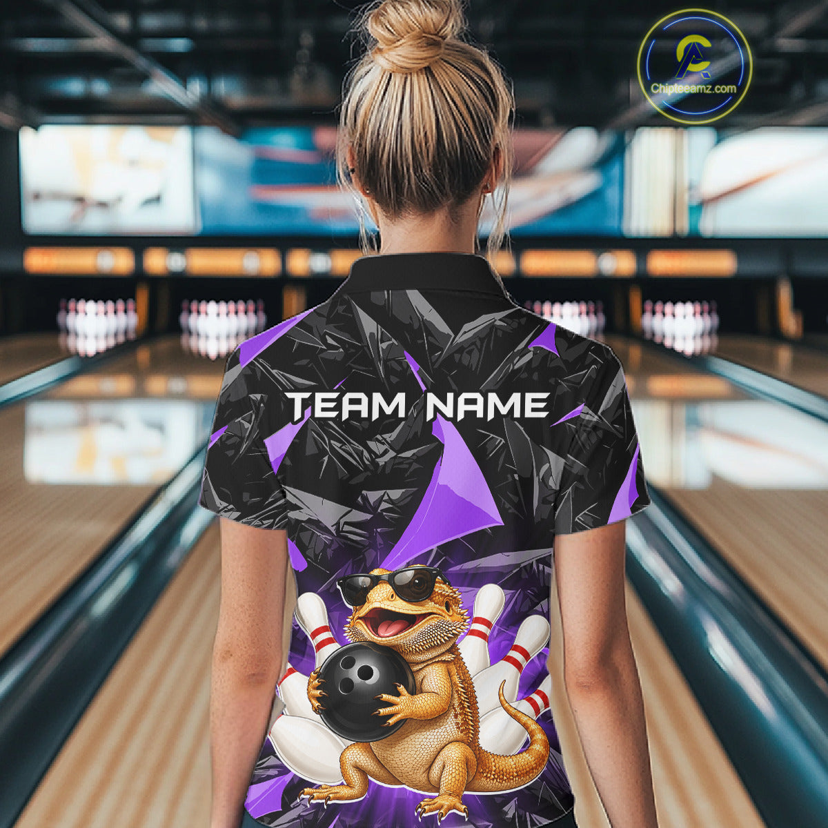 Women’s purple bearded dragon bowling quarter zip shirt, back view on female model in bowling lane 