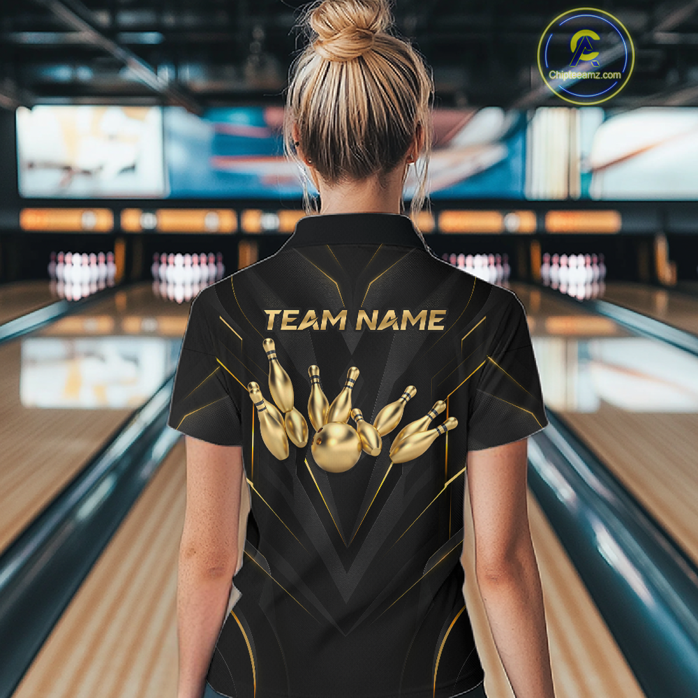 Woman wearing a black bowling shirt with gold designs and 'TEAM NAME' text in a bowling alley.