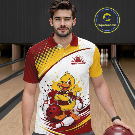 A man wearing a custom bowling-themed polo shirt with a cartoon duck graphic, standing in a bowling alley holding a bowling ball. The shirt features a red, yellow, and white design with a customizable text