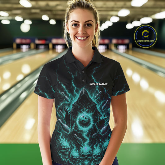A woman stands in a bowling alley wearing a black short-sleeve polo shirt with a glowing teal and purple cosmic/energy graphic and the text 'YOUR NAME' on the chest. 