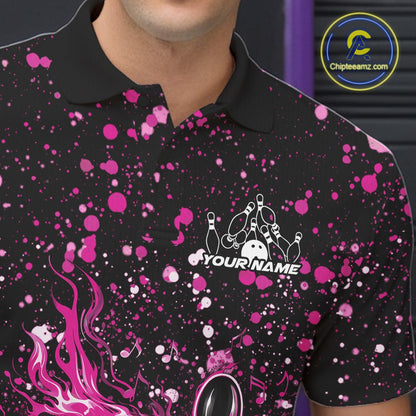 Close-up of the left chest on a black bowling polo shirt featuring flaming bowling pins and pink splatter graphics.
