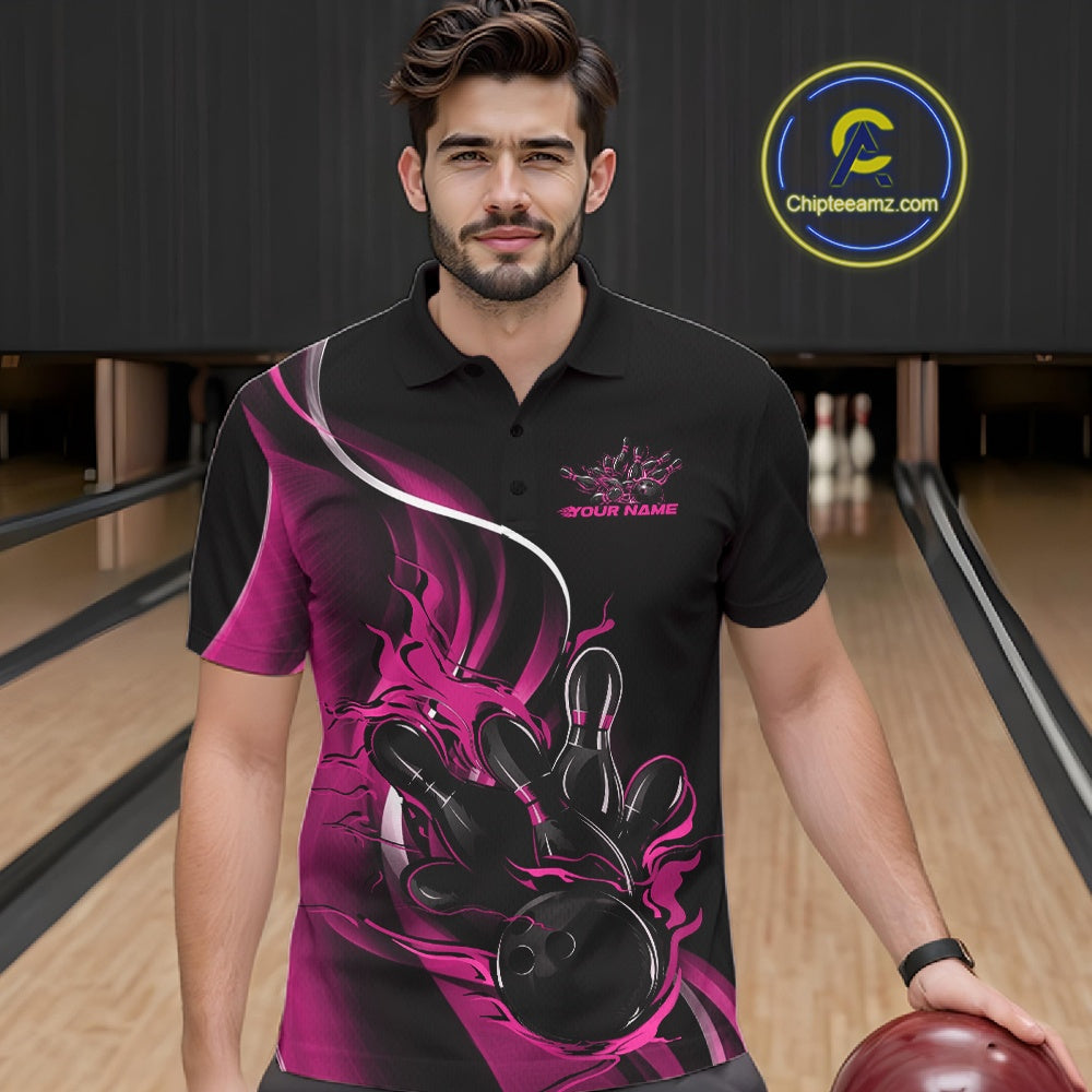Male model seen from the front in a bowling lane wearing a black and pink polo shirt featuring a flame bowling ball striking pins in a dynamic sports action design.