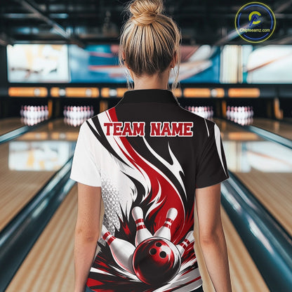 Back view of a female model wearing a white, black, and red bowling quarter zip shirt with a flaming bowling ball and pins graphic at a bowling lane.