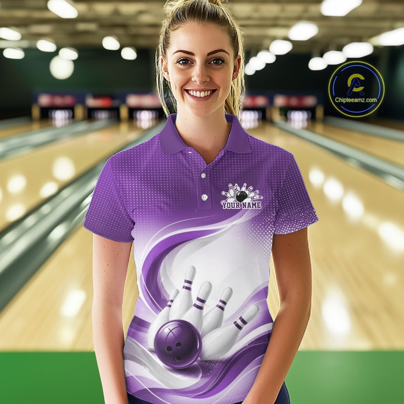 Front view of a womens white and purple bowling polo shirt featuring curved wave motifs and a bowling ball striking the pins