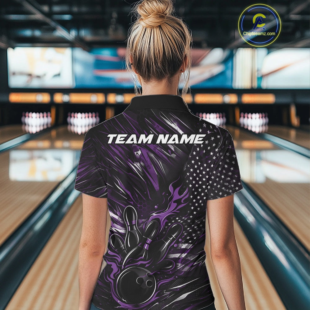 Back view of a female model in a bowling venue wearing a black and purple polo shirt featuring a fiery bowling action scene and flag-inspired graphics.