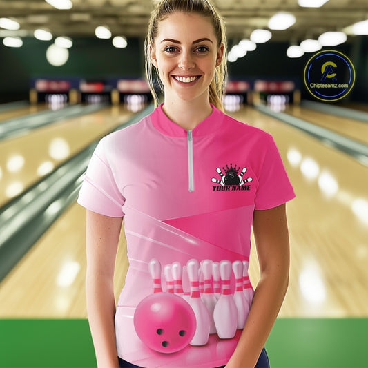 Female model front view in a bowling lane wearing a quarter zip shirt with bowling ball and pins arranged within a pink gradient layout.