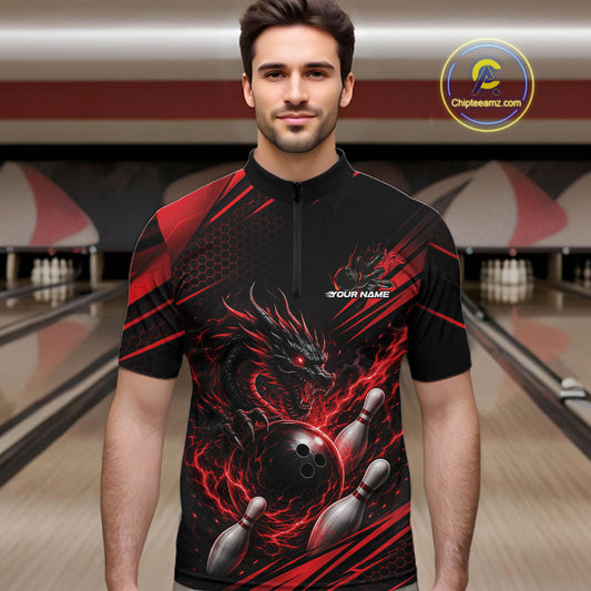 A man wearing a black and red bowling-themed short-sleeve quarter-zip shirt with a dragon and bowling pins graphic, standing in front of a blurred bowling alley background. 