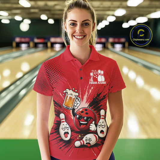 A woman stands in a bowling alley wearing a red short-sleeve polo shirt with a bowling-themed graphic print featuring cartoon bowling balls, pins, and a beer glass. 