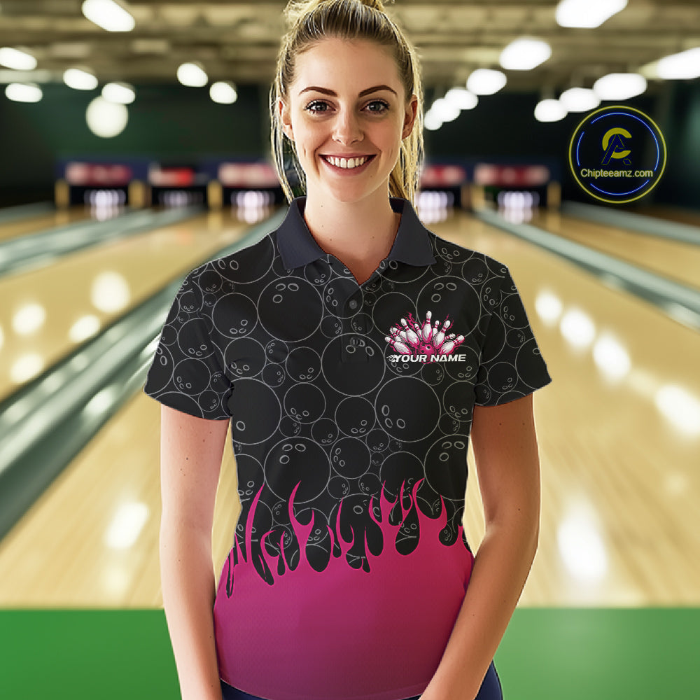 Front view of a female model in a bowling lane wearing a black polo shirt with vibrant pink flames and bowling ball pattern and energetic bowling action visuals.