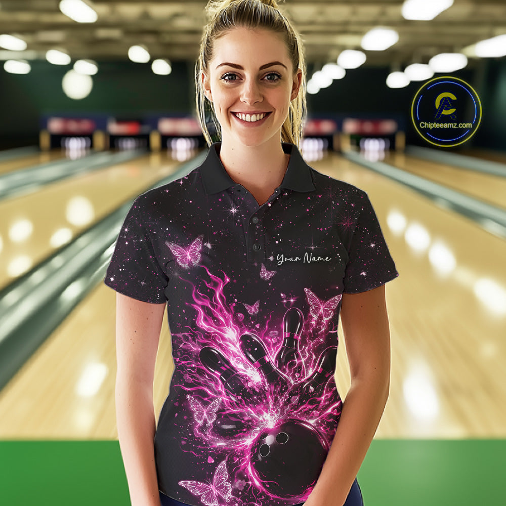 Female model wearing a black and pink bowling polo shirt at the lane with flaming ball, pins, and glowing butterflies.