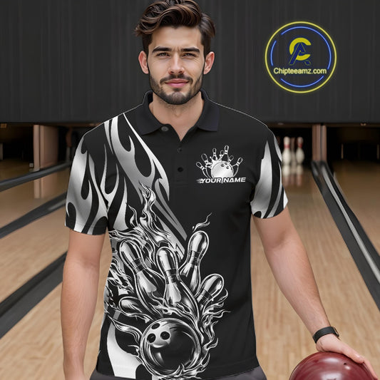 Male model seen from the front in a bowling lane wearing a black polo shirt featuring a silver metal tribal flame bowling ball striking pins in a dynamic sports action scene.