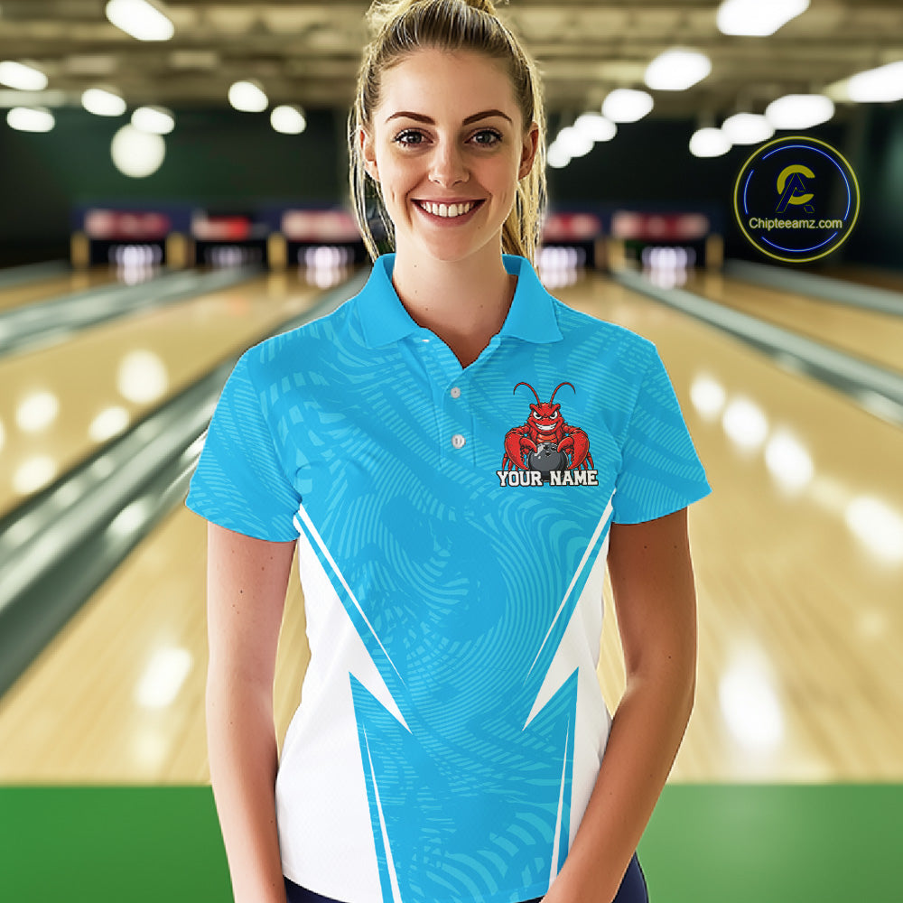 Front view of a female model in a bowling alley wearing a blue custom bowling polo shirt with a funny aggressive crawfish holding a bowling ball in a sportswear-style design.