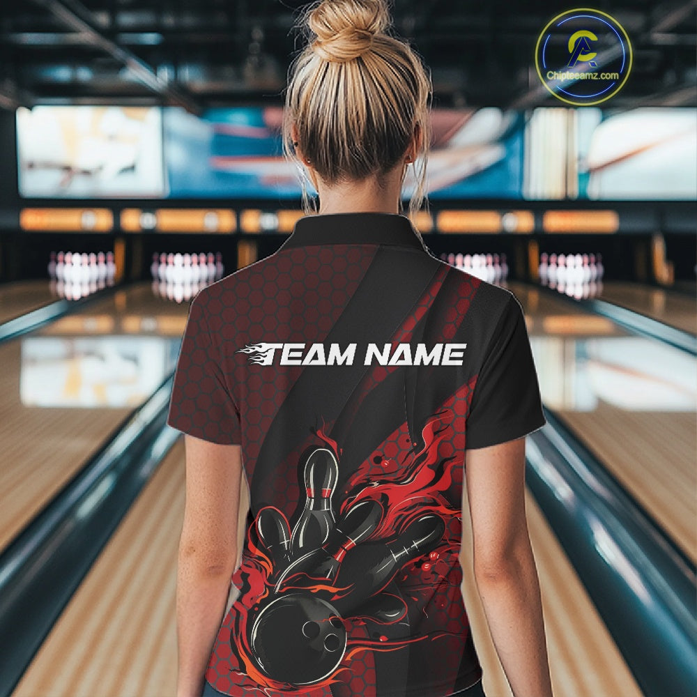 Back view of a female model in a bowling center wearing a black and red polo shirt featuring a flaming bowling ball and pin design.