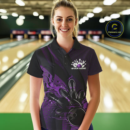 Female model wearing a black and purple bowling polo shirt at a bowling lane with fiery bowling strike artwork and geometric accents.