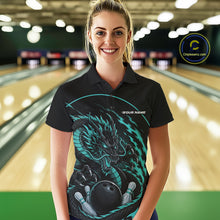 Load image into Gallery viewer, Front view of a female model in a bowling alley wearing a blue custom bowling polo shirt featuring an aggressive dragon with flames in a dynamic and energetic design.
