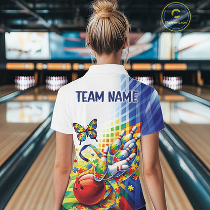 Female model at a bowling lane, back view of white and blue polo shirt with swirling puzzle ribbon and butterfly bowling motif