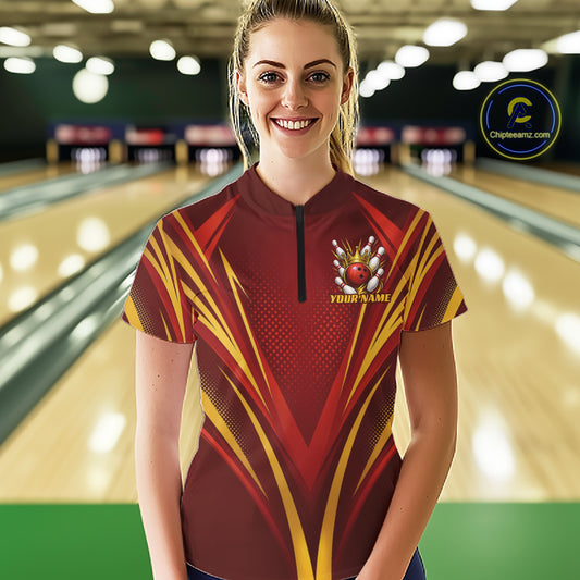 A woman standing in a bowling alley wearing a custom short-sleeve bowling quarter zip jersey with a red and gold bowling with crown design