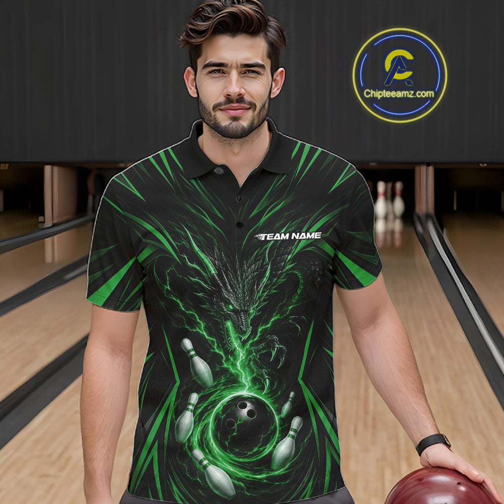 A man wearing a black short-sleeve polo shirt with a green and black bowling-themed graphic print, standing in a bowling alley holding a bowling ball. 