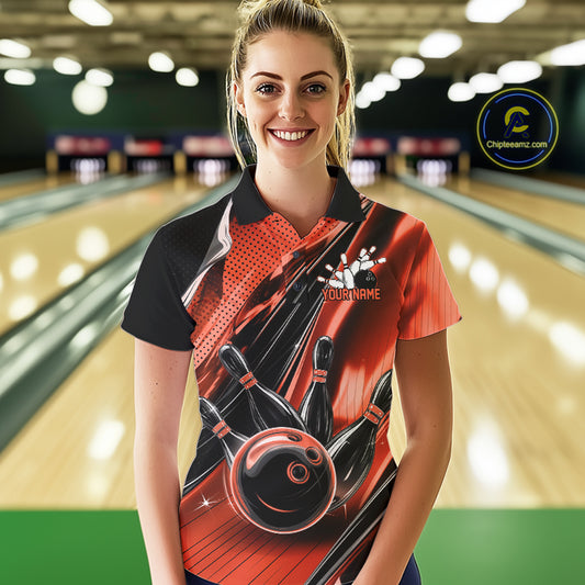 Female model wearing a black and orange bowling polo shirt at the lane with fast-moving bowling ball and pin artwork.