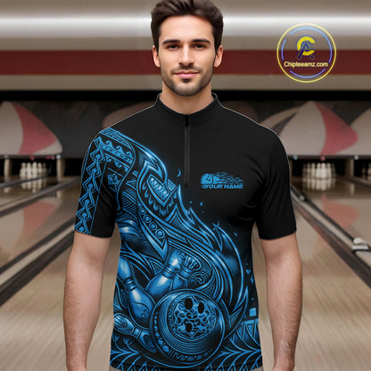 Male model wearing a black and blue bowling quarter-zip shirt at the bowling lane with Polynesian-inspired flame bowling artwork.