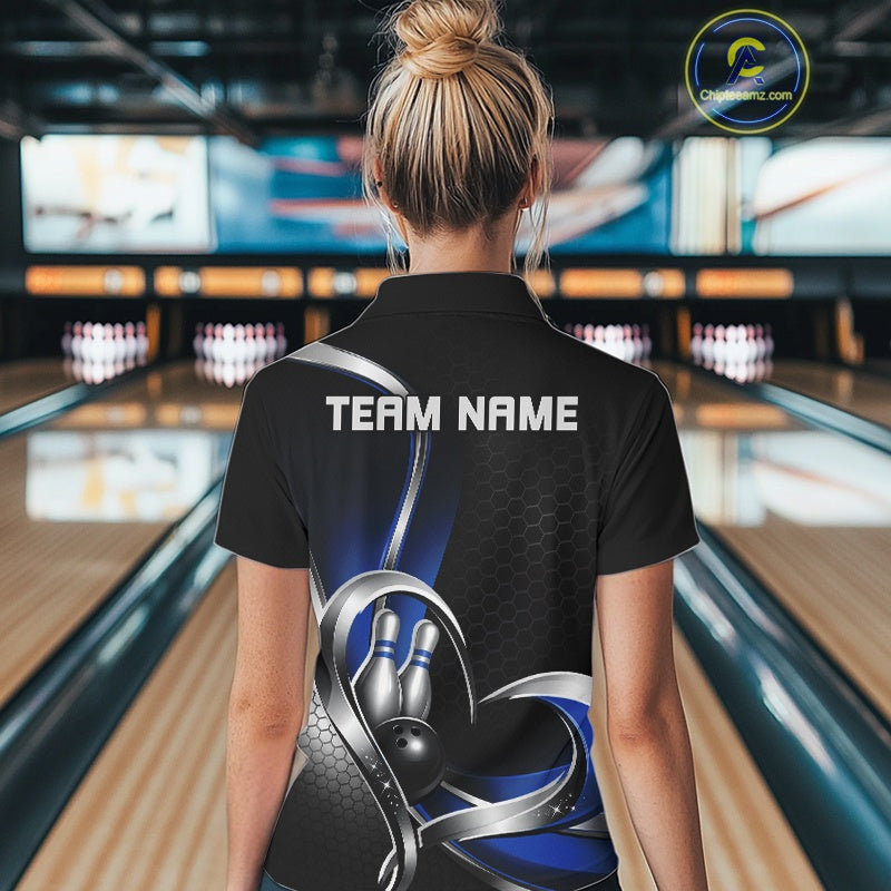 Back view of a female model in a bowling venue wearing a black and blue polo shirt, showcasing honeycomb pattern and heart-shaped bowling ball hitting pins design.